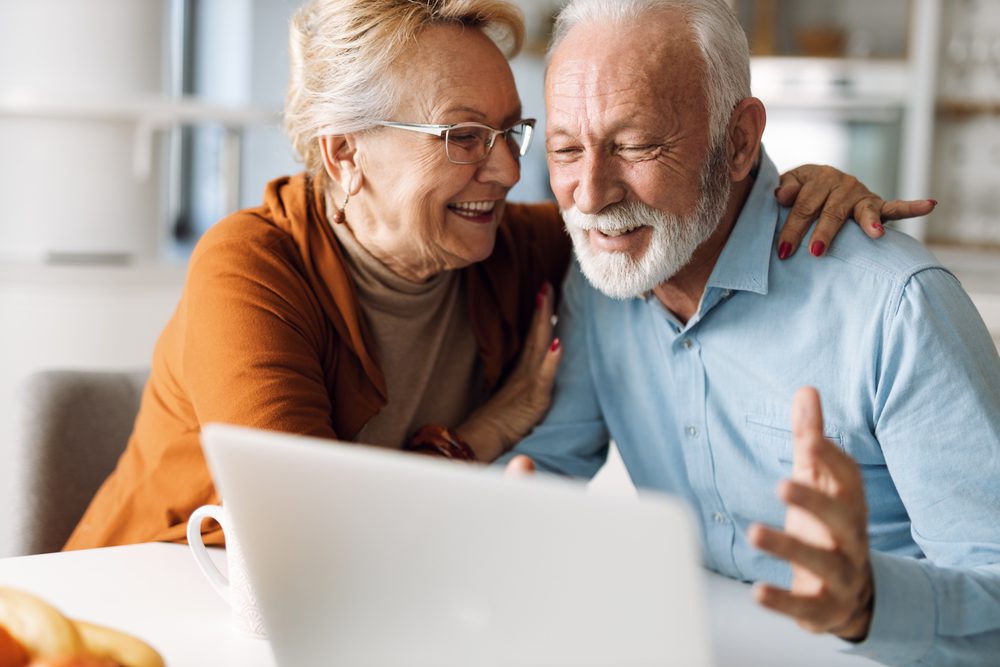 Happy,Mature,Couple,Using,Laptop,At,Home